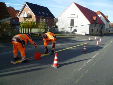 Mitarbeiter des Kreisbauhofes Büren Harth bringen die gelbe Markierung für den Verkehrsversuch auf. (Foto: Kreisverwaltung Paderborn)